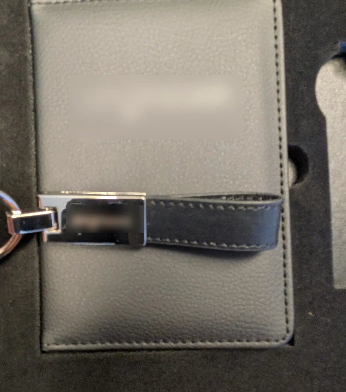 Détail du portefeuille en cuir et du porte-clés cuir et métal d'un welcome pack d'entreprise